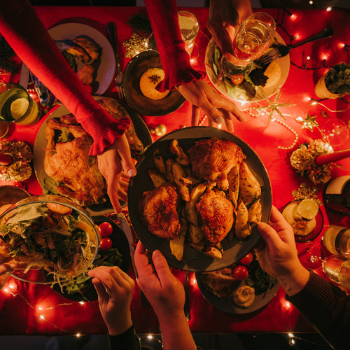 Top view of people enjoying variety of Christmas dishes while having holiday dinner